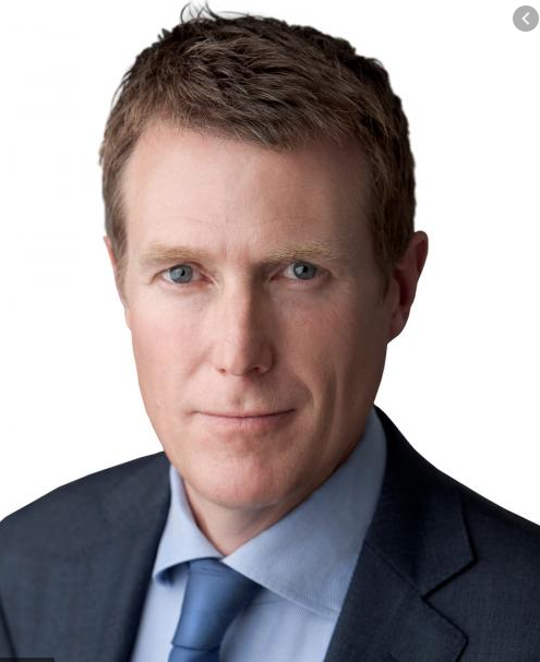 Australian Attorney-General Christian Porter in a dark suit and blue tie, in a head-and-shoulders portrait.