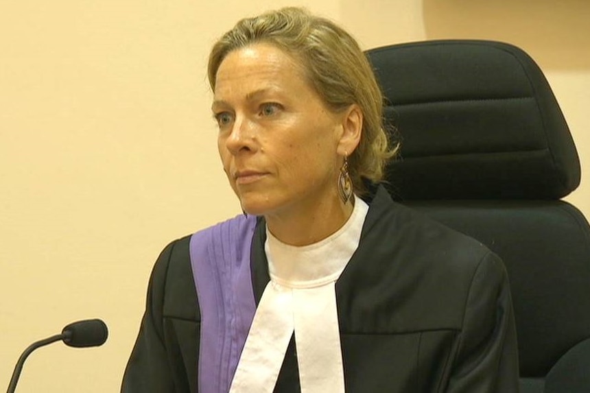 South Australian District Court Judge Joana Fuller on the bench, wearing black judicial robes with a purple sash and a white jabot.
