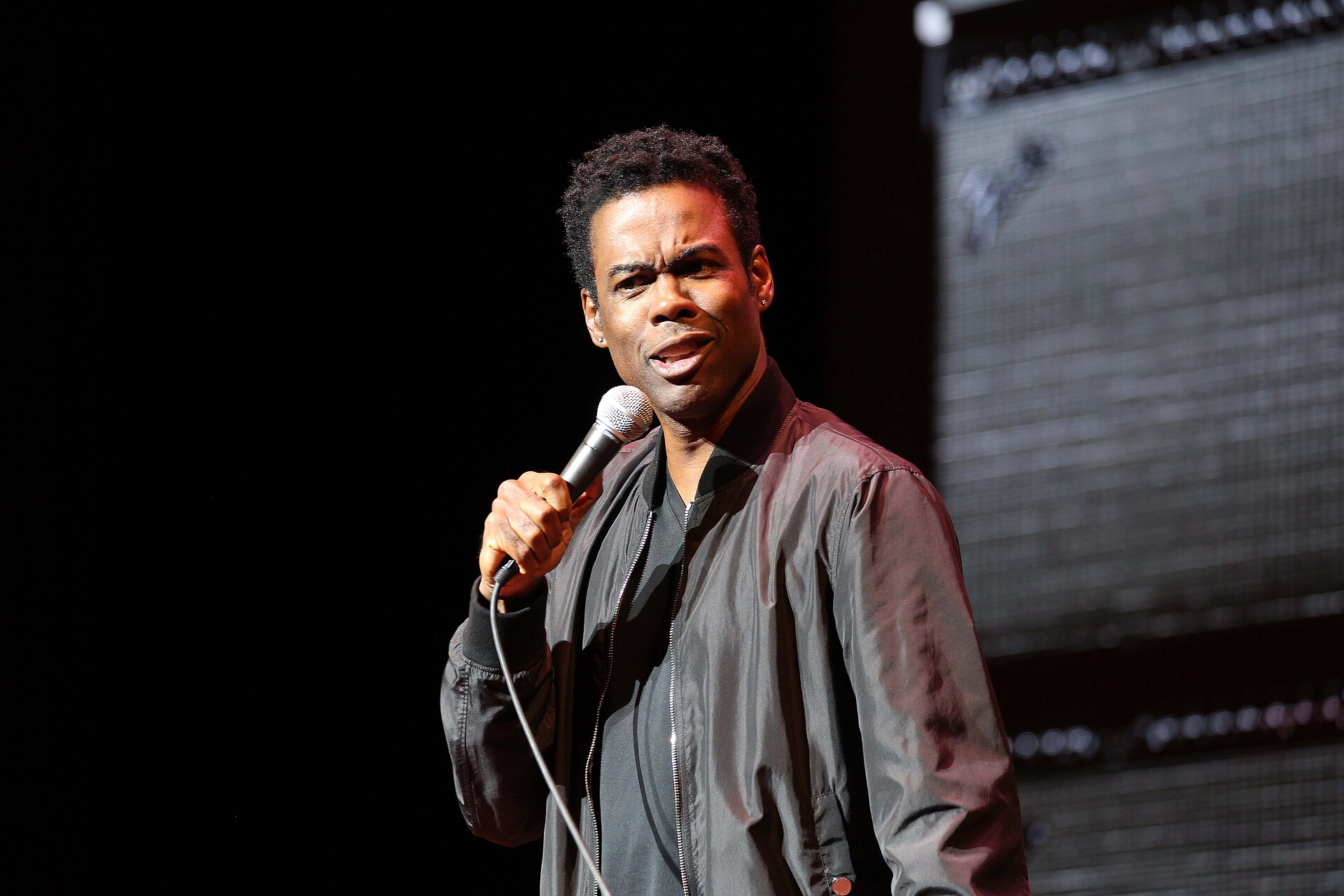 Chris Rock performing stand-up with a microphone at the Orpheum Theatre in Minneapolis in 2017.