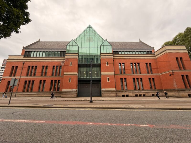 Minshull Street Crown Court in central Manchester, a red-brick building with a glass atrium over its entrance