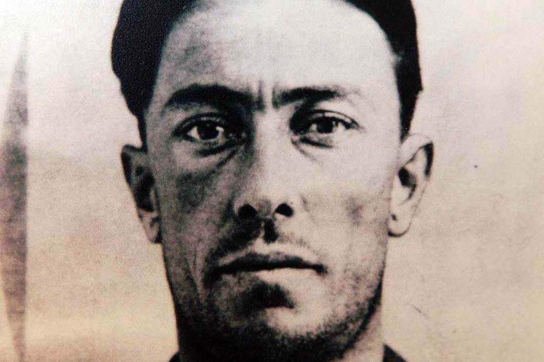 Black-and-white head-and-shoulders portrait of Colin Ross, a dark-haired man with a stern expression, photographed around 1922.
