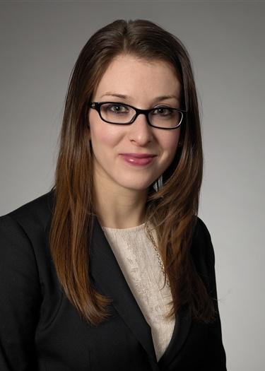Portrait of Assistant United States Attorney Elizabeth Espinosa in a dark jacket and glasses