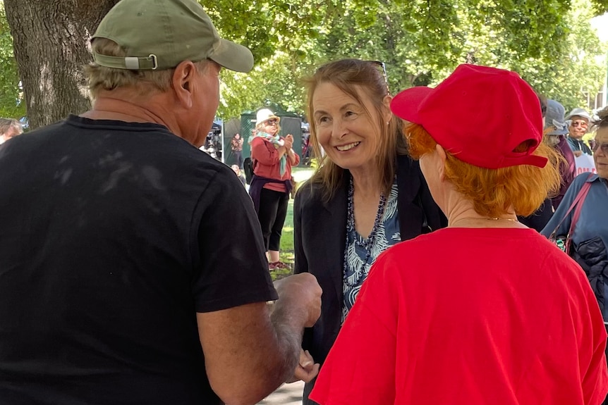 Sue Neill-Fraser smiling at two supporters whose backs are to the camera.